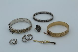 A collection of jewellery comprising a Victorian aesthetic movement bangle, a Greek key silver