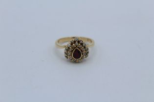 A ruby and diamond pear shaped design dress ring in precious yellow metal, stamped 18k and 750. Size