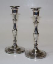 A pair of George III sterling silver weighted candlesticks.  Knopped and reeded stems, to urn