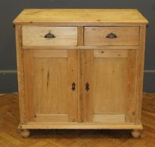 A 19th century pine cupboard, with two short drawers over a pair of panelled cupboard doors,