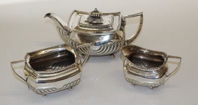 A Sterling silver rectangular outline teapot with curved fluting and ball feet, with ivory heat