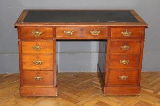 An Edwardian mahogany twin pedestal writing desk, the scriber set top over nine drawers, on plinth