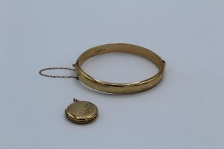 A 9ct gold hinged bangle. Hallmarked. With security chain, approximate weight 12gm, plus a 9ct