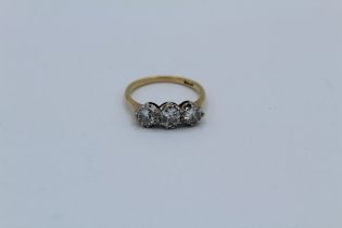 A three stone diamond ring, featuring three Old European cut diamonds, the principal stone measuring