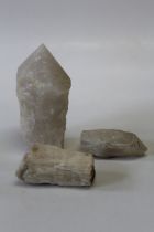 A grouping of minerals featuring two polish quartz points and a large specimen of selenite.