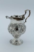 Possibly William Cripps, a George III silver cream with serpentine rim, twin scroll handle, florally