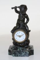 A French bronze desk clock, signed H. Capy, in the form of a putto sat atop a globe, his hand aloft