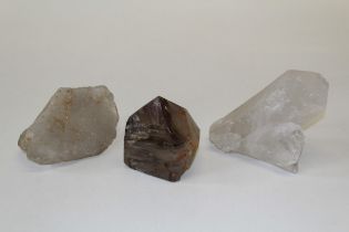 A collection of three large quartz points, one a part polished smoky quartz point, along with a
