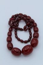 A cherry amber style beaded necklace featuring graduated beads to a screw bead clasp adapted into