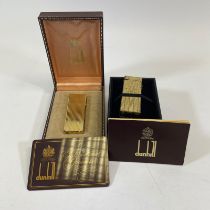 Two Dunhill boxed gold plated lighters.
