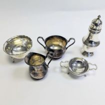 A silver milk jug and sugar bowl.  A silver sugar bowl, strainer, stand and silver castor.  Total