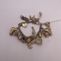 9ct Yellow Gold Charm Bracelet with 16 charms including bagpiper, opening church, ice skate, pistol,