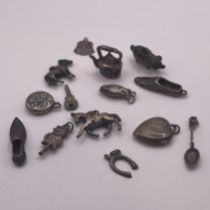 A collection of fourteen silver and white metal charms  including a teapot, donkey, horse, heart