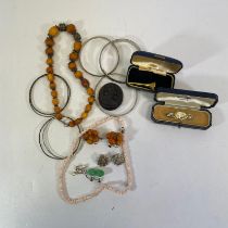 A collection of jewellery including: two silver bangles, a boxed yellow metal golf tee, a pair of