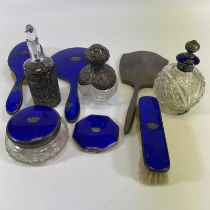 A silver and enamel six piece dressing set, two silver mounted bottles and a silver back mirror.