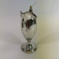 A George III sterling silver helmet cream jug. Marked for Hester Bateman, London 1783.  Decorated