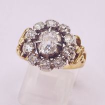 A circa 1820s diamond cluster ring set with a oval cushion cut diamond in a cut down silver collet