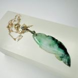 A jade fish pendant on a yellow metal tracer chain. Chain tests as 9ct gold. Gross weight