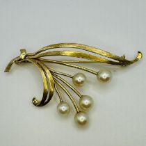 A Mikimoto cultured pearl spray brooch. Featuring the "M" scallop mark and a "14k" stamp. With