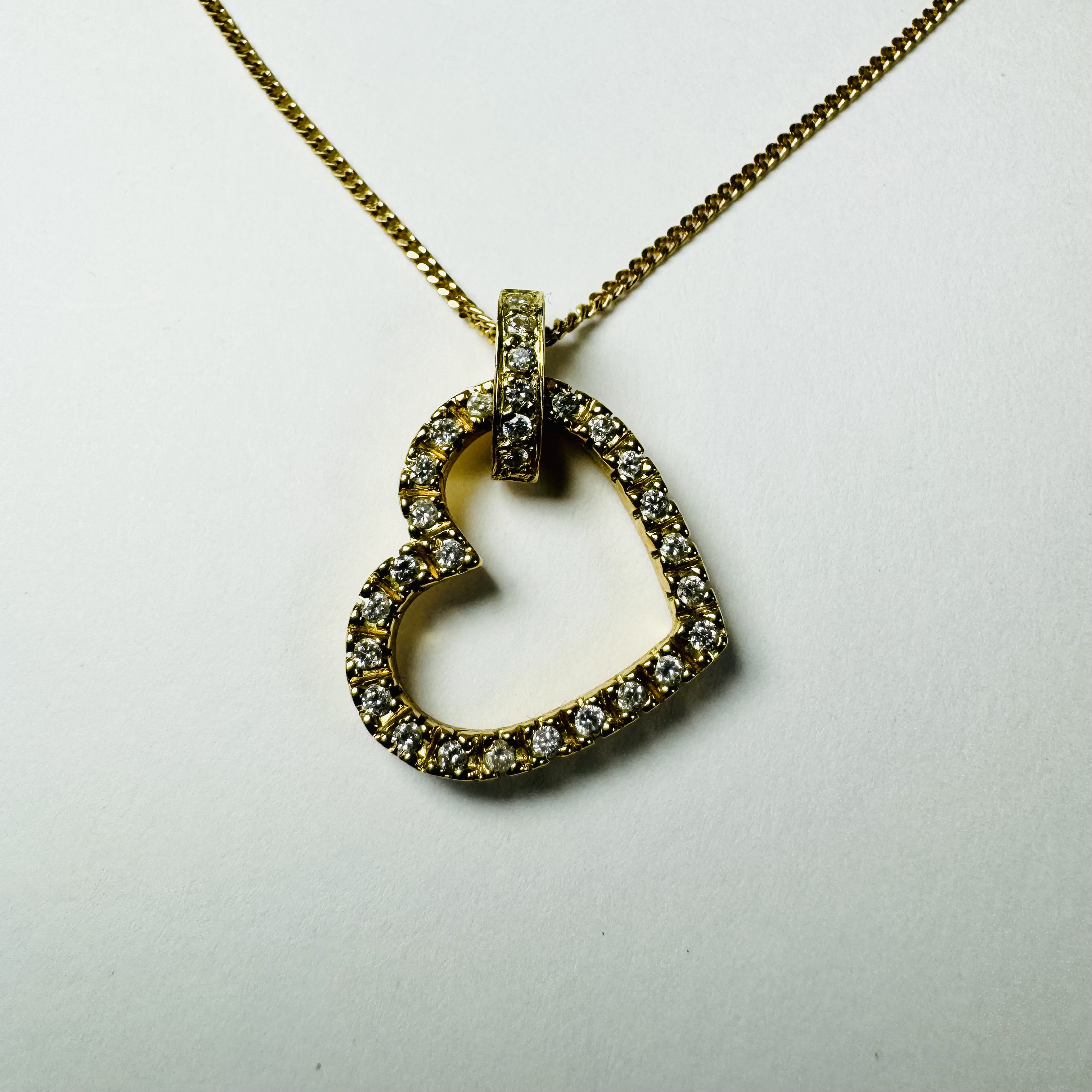 An 18ct gold diamond heart pendant on an 18ct gold chain. Set with 31 1.3mm round brilliant cut
