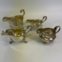 A group of three sterling silver sauce boats and a sterling silver creamer. Comprising a Victorian