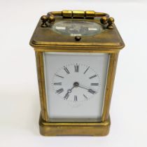 A brass carriage clock striking on a gong with repeat. Approximately 17cm tall with handle up.