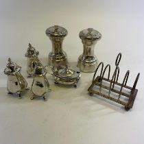 2 silver cased pepper grinders, 4 silver cruet items and a silver toast rack.  Weighable silver