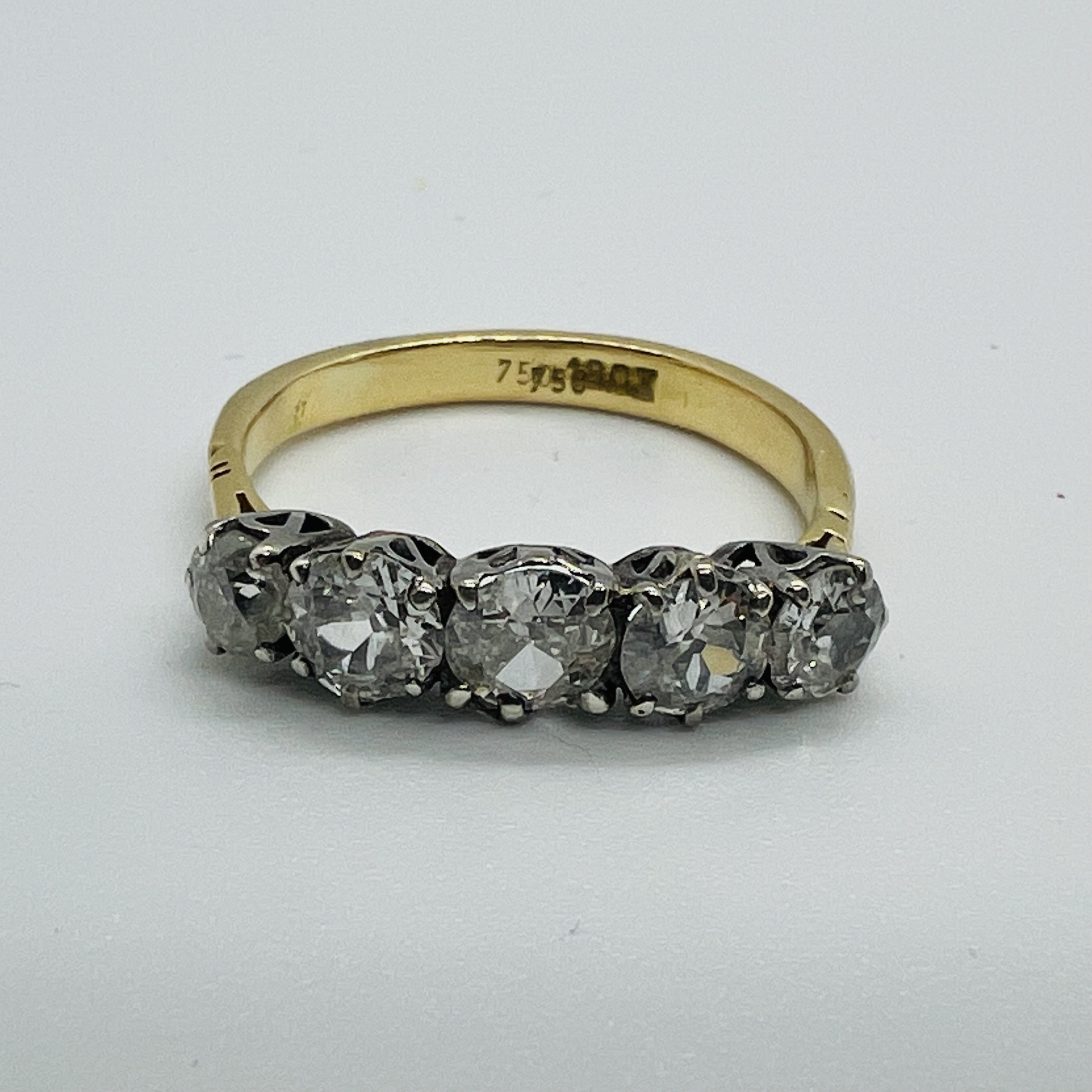 A five stone diamond ring, featuring five graduated old cut diamonds. In precious yellow metal