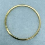 A solid precious yellow metal bangle. Unmarked but surface tests as 9ct yellow gold. Gross weight