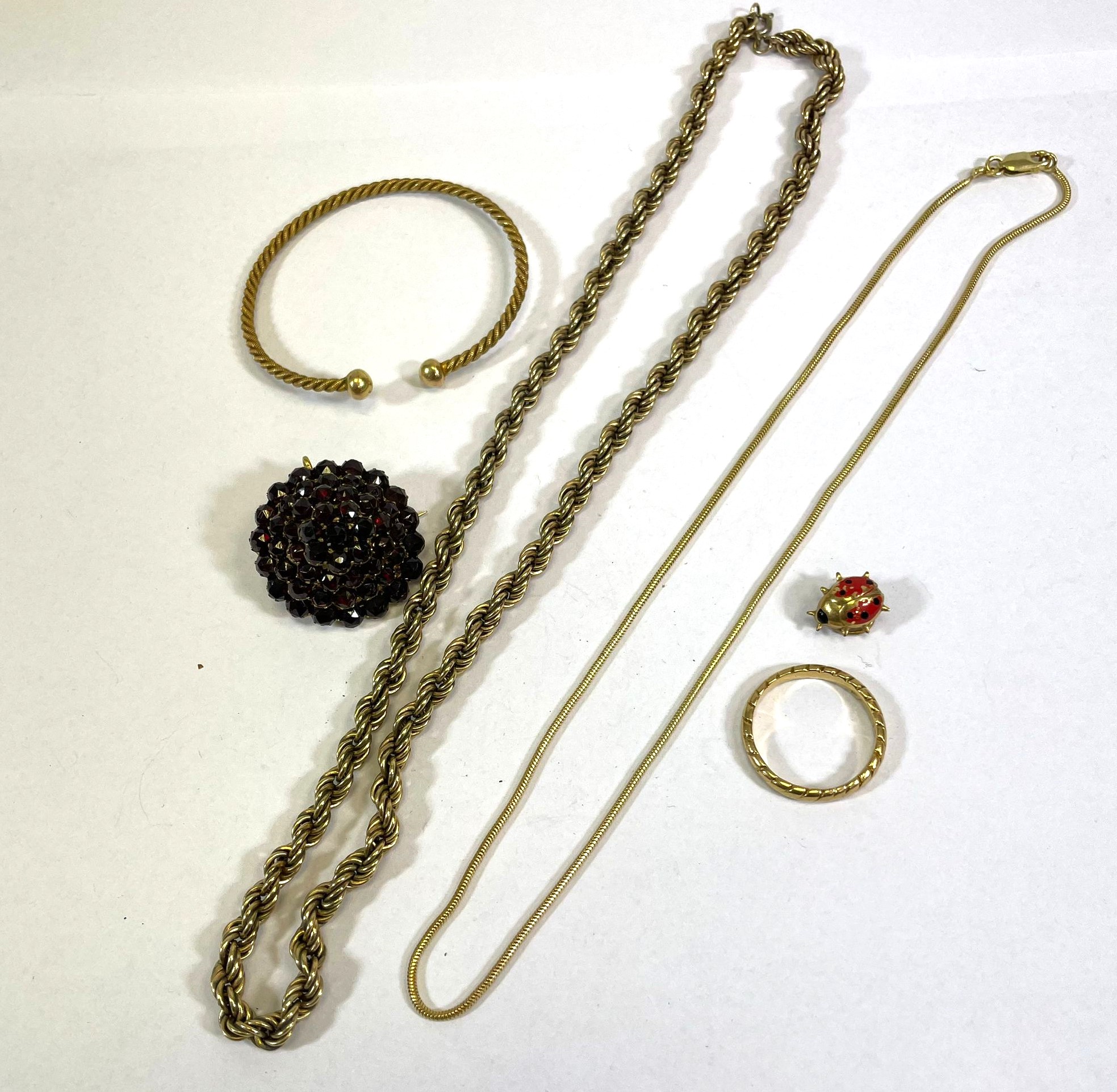 A 9ct yellow gold chain, 40cm long.  A 9ct yellow gold ring, size R.  A gilt metal garnet brooch,