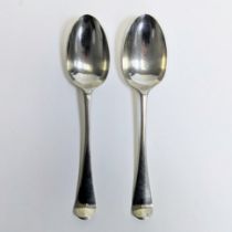 Two Hanoverian pattern silver table spoons, with scroll work to the back of the bowls. With worn