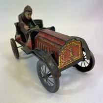 An early 1900's tinplate clockwork car with driver.  21cm long, running with wear consistent with