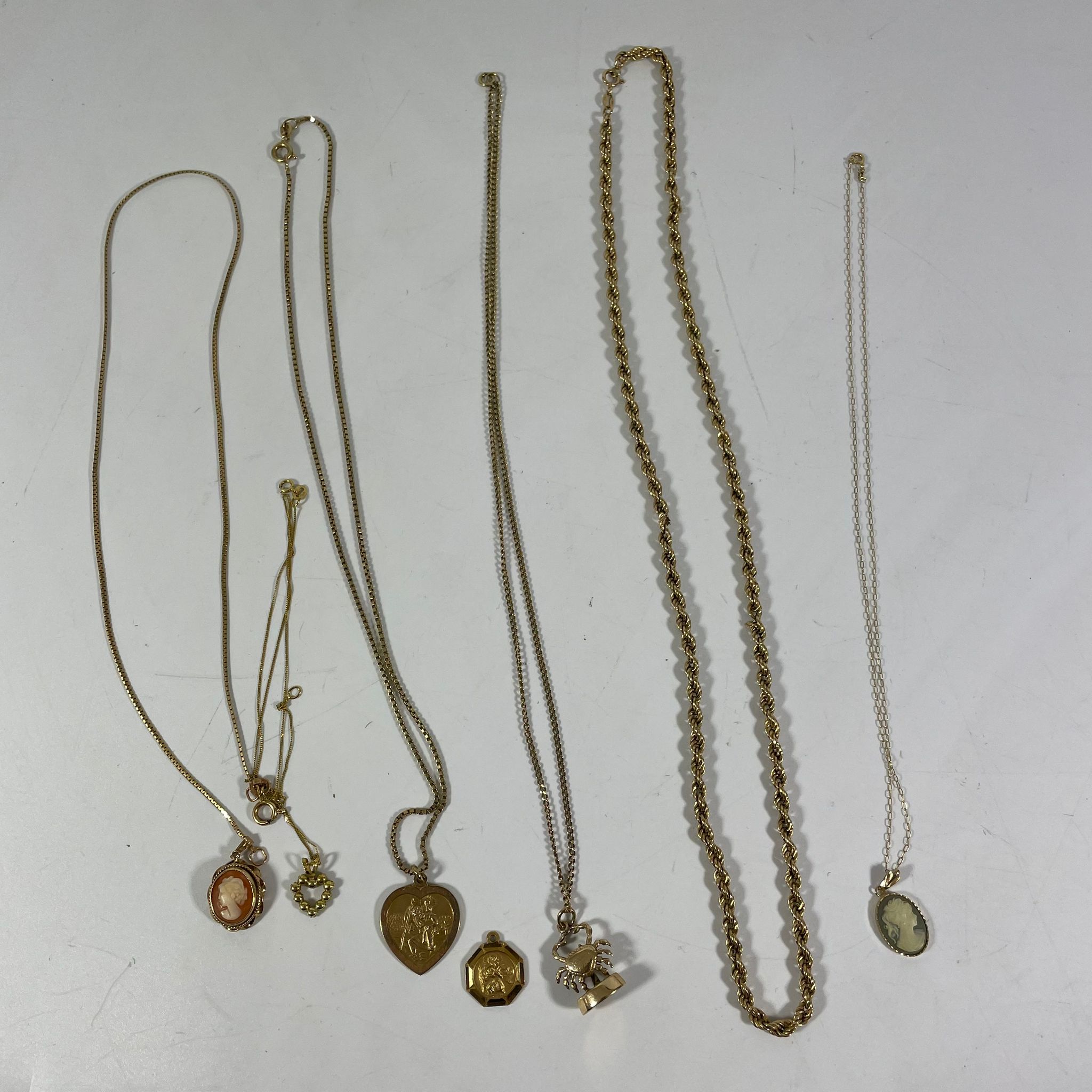 Five 9ct Chains, Four 9ct Pendants, a Gilt Chain and two Gilt Cameo Pendants. Total weight