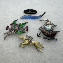 An Aksel Holmsen of Norway enamel brooch, along with four other enamel brooches.  The Holmsen brooch