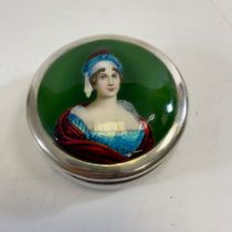 A silver lidded pot with a ladies portrait top. Approximately 8cm wide and 3.5cm tall. Approximate