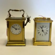 Two brass carriage clocks . Tallest approximately 15 cm tall with handle up. One working with a key,