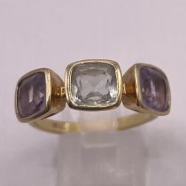 A prasiolite and amethyst 18ct yellow gold ring. Prasiolite (green quartz) central stone flanked