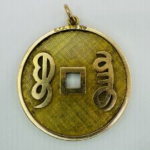 A yellow precious metal Lo Han coin pendant, marked 375.  Tests as 9ct gold. Approximate length from