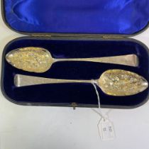 A pair of Regency fruit spoons with bright cut engraving to the handles and with repousse fruit to