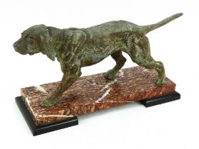 An Art Deco bronzed spelter figure of a gun dog raised on a red marble and slate base. Length 33cm