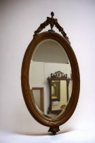 A 19th century oval wall hanging mirror with original Victorian bevelled glass, regency style