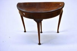 A reproduction of the 20th Century George III style demilune card table.