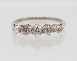 A diamond and platinum set ring, comprising five graduated old cut diamonds, total diamond weight