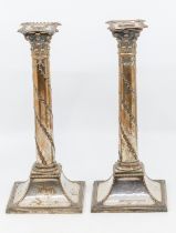 A pair of 19th Century Regency silver plated candle sticks on square bases with foliage design. each
