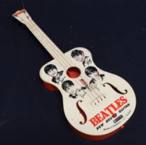 A novelty The Beatles miniature guitar having printed faces and signatures to front.