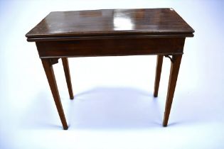 A George III fold over tea table standing on tapered legs.