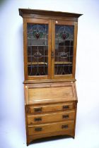 A late 19th Century/early 20th Century arts and crafts glazed birch bookcase with three drawers