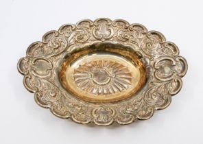 A late Victorian silver oval trinket dish, having elaborate embossed foliage design, scrolled