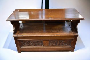 A mid 20th Century solid oak monk's bench with carved detail.