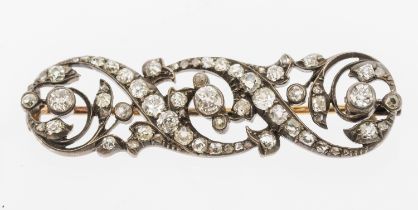 A Victorian diamond set brooch, comprising scroll decoration set with old cut diamonds, the three